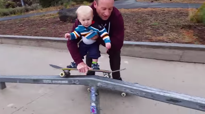 Radical little baby dude grinds out a rail on his skateboard.