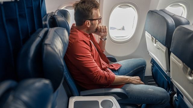 Man in middle plane seat moves knee into woman's space; she calls attendant. AITA?